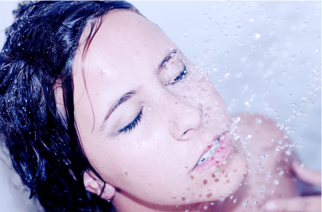 【シャワーの時間を最高のリラックスタイムに】マッサージ効果があるシャワーヘッドについて　シャワーを浴びる女性の図